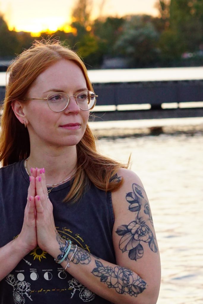 Portrait von Feli von upfox yoga and breath mit Händen im Anjali Mudra (Hände sind vor dem Herzen zusammengelegt)